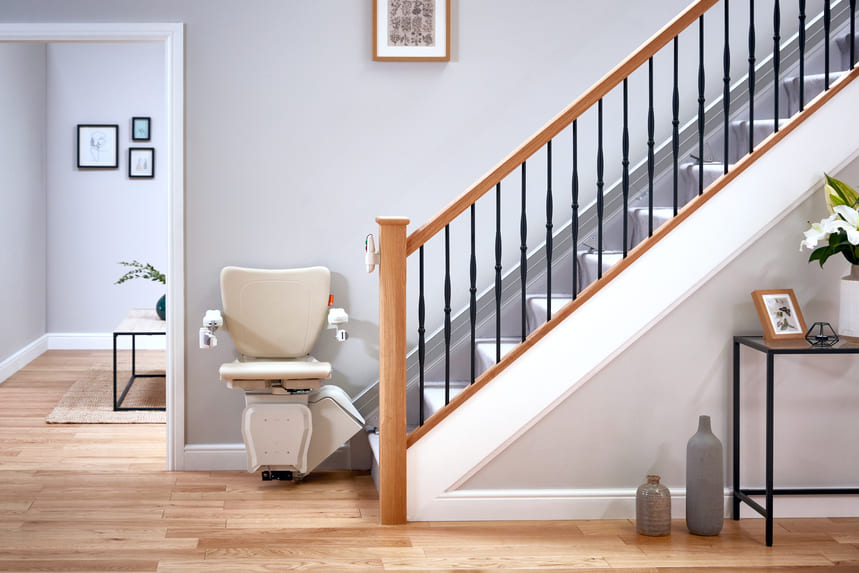 An einer geraden Treppe ist ein Sitz-Treppenlift montiert.